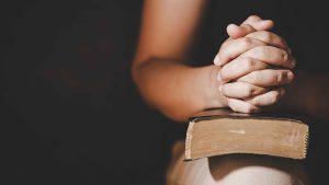 Praying hands on Bible