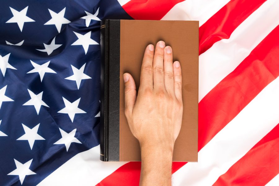top view of a hand on a book on an American flag