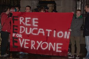 Students holding "free education for everyone" banner.